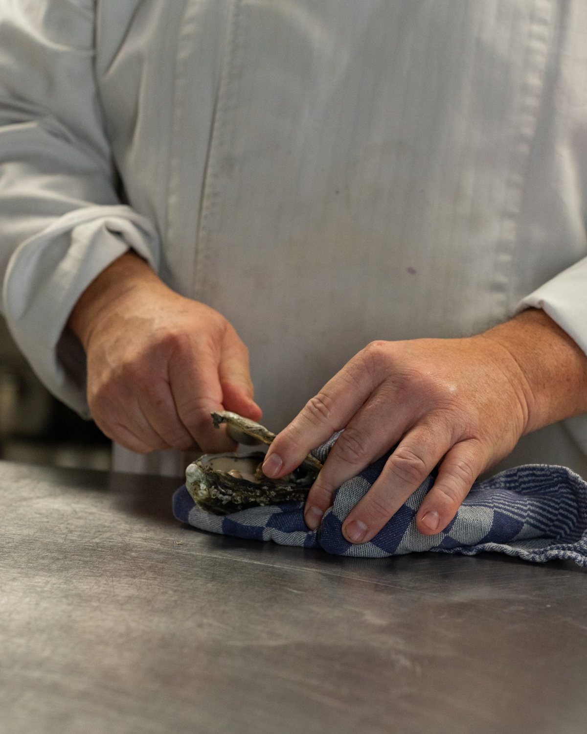 In de open keuken worden oesters geopend boven een werkblad