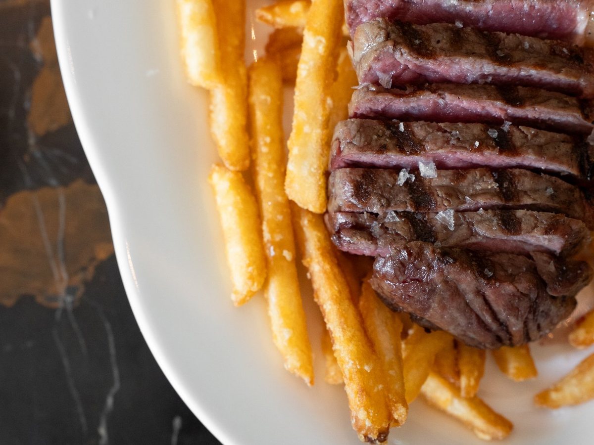Gesneden steak met frites op een wit bord